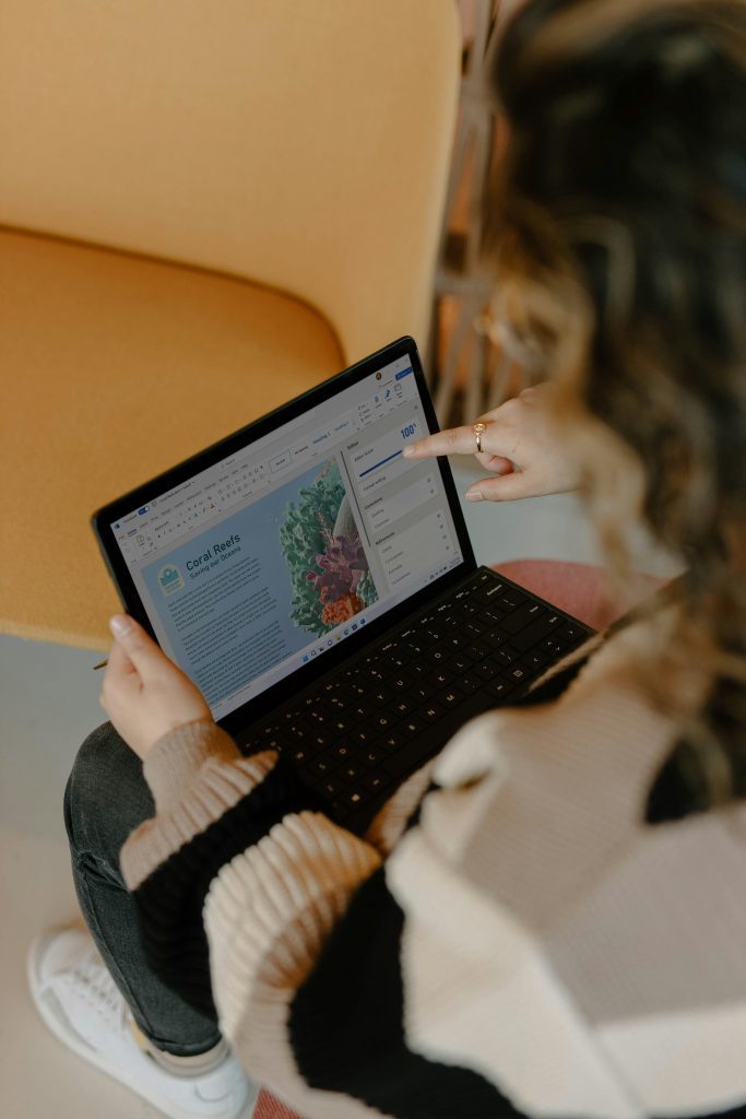 Lady working remotely with a laptop in front.