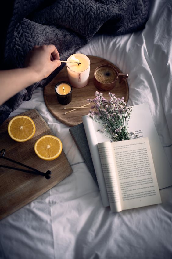 Warm reading setting with scented candle and baby breath aesthetic.